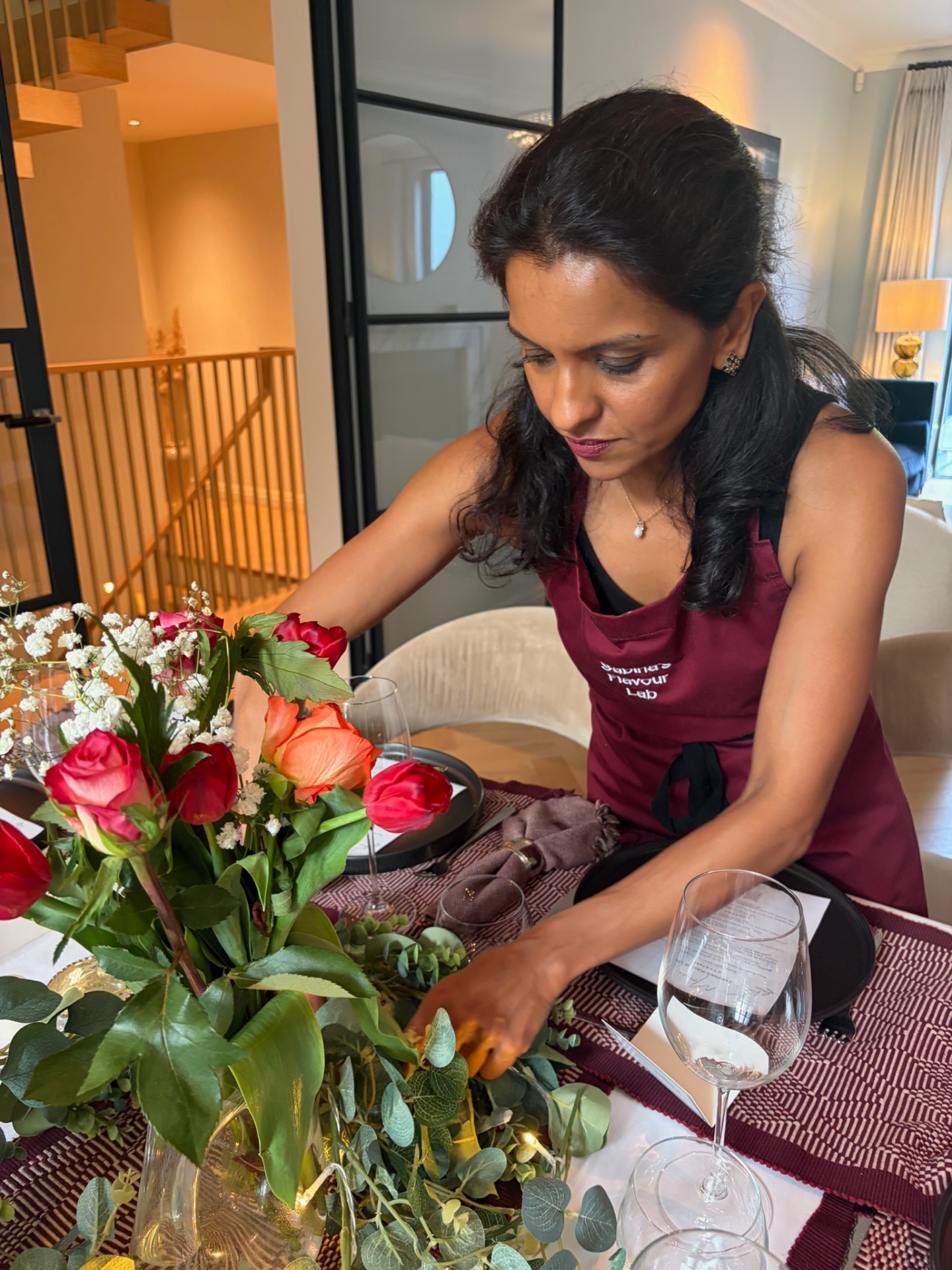 Sabina arranging flowers and place settings for a private dinner