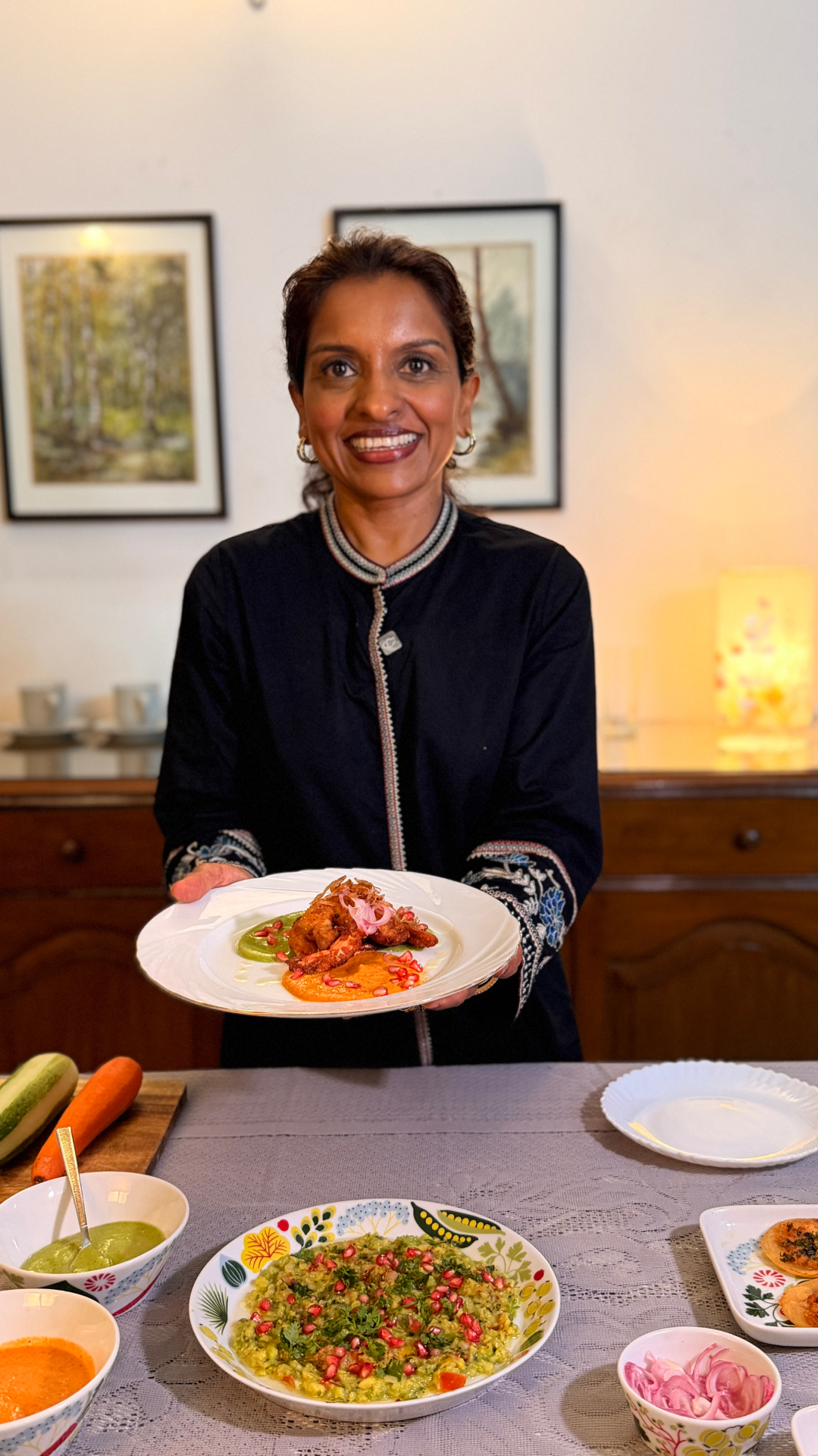 Sabina holding a finished dish at the table