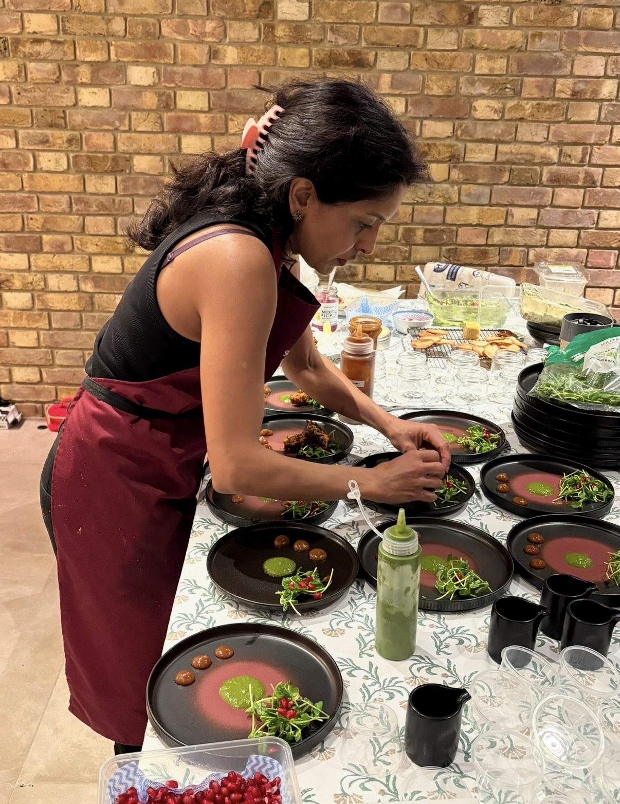Sabina plating supper club dishes in her burgundy apron